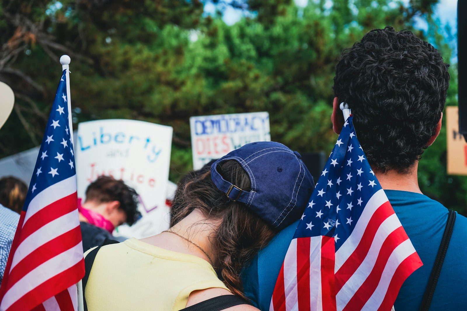 People holding american flags at a rally